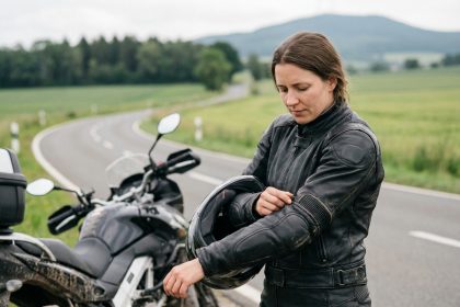Femme en équipement moto inspectant sa veste en cuir noir