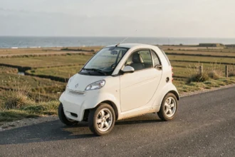 Voiture sans permis blanche garée au bord d'une route côtière en Vendée